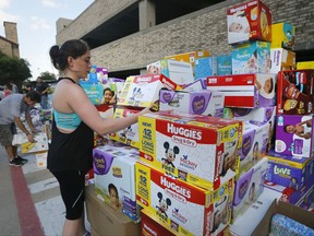 Volunteer Elizabeth Haley organizes boxes of infant diapers donated for hurricane Harvey victims at a North Dallas donation drop off location, Tuesday, Aug. 29, 2017. (AP Photo/Tony Gutierrez)