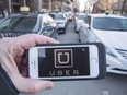 The Uber logo is seen in front of protesting taxi drivers in Montreal in 2016.