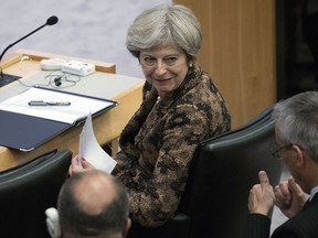 British Prime Minister Theresa May speaks to an aid during a high level meeting on the situation in Libya, Wednesday, Sept. 20, 2017 at United Nations headquarters. (AP Photo/Mary Altaffer)