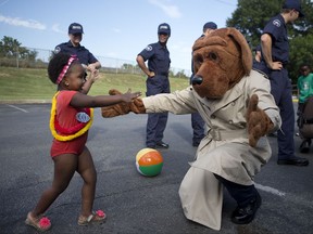FILE - In this Aug. 2, 2016, file photo, Ariana Phillips, 3, gives a hug to McGruff the Crime Dog, as Roanoke Police Academy recruit class 7237 watch in the background during National Night Out at Afton Garden Apartments in Roanoke, Va. John "Jack" Keil, the advertising executive who led the team that created McGruff the Crime Dog and who voiced the character has died. The family of Keil said he died Aug. 25, 2017, at home in Westminster West, Vt. He was 94. (Erica Yoon/The Roanoke Times via AP, File)