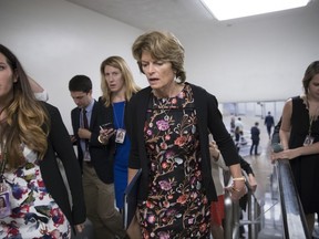 In this Sept. 19, 2017, photo, Sen. Lisa Murkowski, R-Alaska, speaks with a reporter as she arrives for a vote at the Capitol in Washington. Provisions shoehorned into the Republican health care bill dangle extra money for Alaska and Wisconsin, home states of one GOP senator whose vote party leaders desperately need and another who co-sponsored the legislation, according to analysts who've studied the legislation. (AP Photo/J. Scott Applewhite)