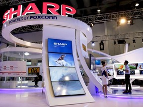 In this Thursday, Sept. 7, 2017, photo, a man plays a video game at Foxconn's exhibition booth promoting its Sharp 8K flat screen TV in Beijing. The Wisconsin Senate approved nearly $3 billion in cash payments for Foxconn Technology Group on Tuesday, Sept. 12, 2017 while also giving the Taiwanese company a slightly less expedited path to the state Supreme Court for certain legal challenges related to a planned massive electronics manufacturing factory. (AP Photo/Andy Wong)