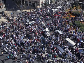 Public sector employees hold a protest in front of the government building in downtown Beirut, Lebanon, Tuesday, Sept. 26, 2017. Lebanon's civil servants are on strike to pressure the government to pay them recently approved wage hikes amid a new crisis over how to finance the wages bill, estimated at $800 million. (AP Photo/Bilal Hussein)