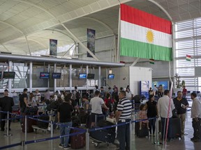 Travelers line up to check in at the Irbil International Airport, in Iraq, Wednesday, Sept. 27, 2017. Iraq's prime minister ordered the country's Kurdish region to hand over control of its airports to federal authorities or face a flight ban, a response to the Kurdish independence referendum. (AP Photo/Bram Janssen)