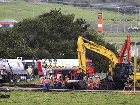 In this Friday, Sept. 15, 2017 photo, New Zealand Refinery staff work at the site of a jet fuel pipeline leak on a farm near Ruakaka in the North Island of New Zealand. A rupture in the main pipeline carrying jet fuel to New Zealand's largest airport has disrupted the travel plans of thousands of people and is expected to cause further flight cancellations and delays through next week. (John Stone/Northern Advocate via AP)