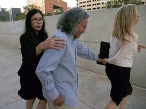 Billionaire founder of Insys Therapeutics John Kapoor, center, is escorted out of U.S. District Court after being arrested earlier Thursday, Oct. 26, 2017, in Phoenix. Kapoor and other defendants in the fraud and racketeering case are accused of offering bribes to doctors to write large numbers of prescriptions for a fentanyl-based pain medication meant only for cancer patients with severe pain. A judge set bail at $1 million for Kapoor, saying he must wear electronic monitoring and surrender his passports. (AP Photo/Ross D. Franklin)