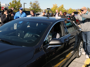 Pepole crowd around an autonomous car after it drove down an Ottawa street after the City of Ottawa and Blackberry QNX demonstrated the vehicle