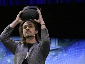 Microsoft Technical Fellow Alex Kipman holds an HMD Odyssey virtual reality headset, Tuesday, Oct. 3, 2017, in San Francisco. Microsoft is touting virtual reality headsets made by other companies in hopes of establishing personal computers running on its Windows 10 operating system as the best way for people to experience artificial worlds. The devices unveiled on Tuesday include a Samsung headset called the HMD Odyssey. The $500 headset requires a connection to a PC running on a Windows 10 update being released Oct. 17. (AP Photo/Ben Margot)
