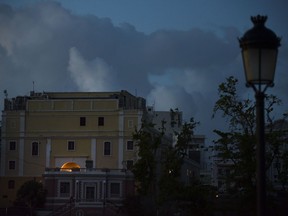 In this Friday, Oct. 20, 2017 photo, the streets of Old San Juan are dark after sunset one month after Hurricane Maria in San Juan, Puerto Rico. Tourism, a rare thriving sector on the island in a deep economic slump, is practically nonexistent a month after Hurricane Maria swept though. (AP Photo/Carlos Giusti)