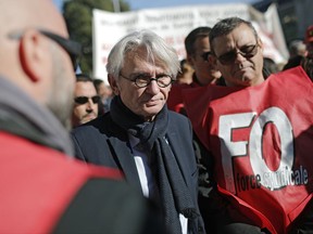 Force Ouvriere (FO) union leader Jean-Claude Mailly, center, demonstrates with French public servants against President Emmanuel Macron's moves to weaken unions and empower employers to change workplace rules, in Lyon, central France, Tuesday, Oct. 10, 2017. A strike by French public sector workers is affecting schools, hospitals and public services and causing disruptions in domestic air traffic. (AP Photo/Laurent Cipriani)
