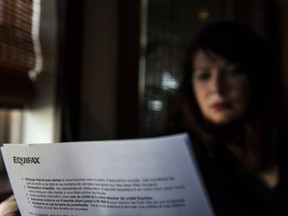 Robin Harvey poses in her Toronto home with a letter she received from Equifax advising her that her personal data had been compromised by a computer hack, on Thursday, October 19, 2017. THE CANADIAN PRESS/Christopher Katsarov