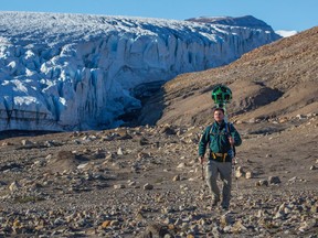 A Parks Canada staff member hikes near Air Force Glacier with the Google trekker in Quttinirpaaq National Park in Nunavut