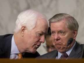 Senate Majority Whip Sen. John Cornyn, R-Texas., left, speaks with Sen. Lindsey Graham, R-S.C., right, during a Senate Judiciary Committee hearing on Capitol Hill in Washington, Tuesday, Oct. 3, 2017, on the Trump Administration's decision to end Deferred Action for Childhood Arrivals otherwise known as DACA. (AP Photo/Andrew Harnik)