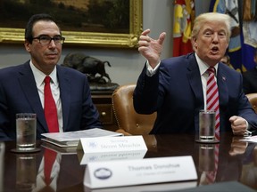 Treasury Secretary Steve Mnuchin listens as President Donald Trump speaks during a meeting on tax policy with business leaders in the Roosevelt Room of the White House, Tuesday, Oct. 31, 2017, in Washington. (AP Photo/Evan Vucci)