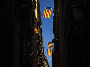 Esteladas or Independence flags and Spanish flags hang on balconies along a street in downtown Barcelona, Spain, Tuesday, Oct. 24, 2017. Catalonia's political leaders said Tuesday they are going to Spanish and international courts in an attempt to prevent Spain's government removing them from power and to proceed with their drive for the region's independence. (AP Photo/Emilio Morenatti)