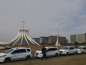 Taxis line a street outside the Brazilian Congress during a demonstration to show support for a bill aimed at regulating ride-sharing apps that the Senate is expected to take up Tuesday, Oct. 31, 2017, in Brasilia, Brazil. The lower house of Congress has passed a bill that would require municipal governments to regulate ride-sharing apps like Uber. (AP Photo/Eraldo Peres)