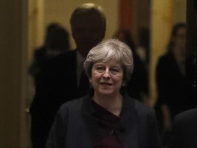 Britain's Prime Minister Theresa May leaves 10 Downing Street in London,  as the capital was bathed in an orange sky Monday, Oct. 16, 2017. The unusual hue of the sky was thought to be due to the remnants of the hurricane dragging in tropical air and dust from the Sahara. Later May will have a dinner meeting in Brussels with senior European Union officials on Monday, in hopes of reinvigorating stalled negotiations on Britain's departure from the European Union. (AP Photo/Frank Augstein)