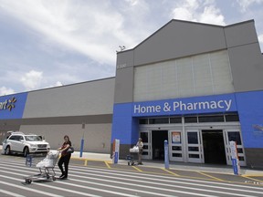 In this Thursday, June 1, 2017, photo, customers walk out of a Walmart store in Hialeah Gardens, Fla. Walmart is expected to provide an update about its expansion plans and issue an outlook for revenue and earnings at its annual shareholder meeting, Tuesday, Oct. 10, 2017. (AP Photo/Alan Diaz)