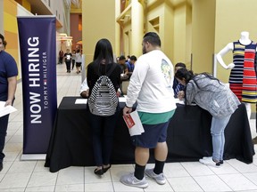 In this Tuesday, Oct. 3, 2017, photo, job seekers check in at a booth at a job fair at the Dolphin Mall in Sweetwater, Fla. On Wednesday, Oct. 11, 2017, the Labor Department reports on job openings and labor turnover for August. (AP Photo/Alan Diaz)