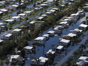FILE - In this Sept. 16, 2017, file photo, this aerial photo shows flooded homes of Citrus Park in Bonita Springs, Fla., six days after Hurricane Irma. The same technology that connected students and teachers in the aftermath of hurricanes Harvey and Irma is easing their transition back to class. That technology includes smartphone exchanges, social media, messaging apps and websites. (Nicole Raucheisen/Naples Daily News via AP, File)