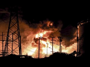 In this Tuesday, Oct. 17, 2017, photo provided by Jack Zellweger, a fire rages at the Chevron El Segundo Refinery in El Segundo, Calif. A fire that erupted at the West Coast's largest oil refinery threatened storage tanks and sent huge flames into the sky and black smoke across neighborhoods before crews quickly smothered it. Dozens of firefighters responded late Tuesday to the 1,000-acre refinery just south of Los Angeles, which processes nearly 275,000 gallons of crude per day. (Jack Zellweger via AP)