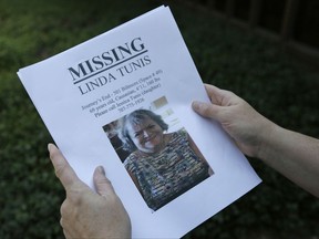 File - In this Oct. 11, 2017 file photo, Jessica Tunis stands outside a Red Cross evacuation center and holds a flyer about her then missing mother, who was later found dead, in Santa Rosa, Calif. The deadliest and most destructive series of wildfires in California history burned thousands of buildings and sent tens of thousands of people fleeing their homes, but the death toll is likely to remain relatively low. Only 42 bodies have been found more than a week after wildfires started, a surprising figure given that complete neighborhoods were wiped out in the dead of night and hundreds of people were initially reported as missing. (AP Photo/Eric Risberg, File)