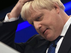 Britain's Foreign Secretary, Boris Johnson, holds his head as he delivers his speech at the Conservative party conference at the Manchester Central Convention Complex in Manchester, England, Tuesday Oct. 3, 2017. Johnson used his Tory conference speech to praise Prime Minister, Theresa May, and insist the Cabinet is entirely united behind her approach to Brexit. The Foreign Secretary, whose own "red lines" on Brexit have overshadowed the Conservative Party conference and led to calls for her to sack him from her Cabinet, paid tribute to the Prime Minister. (Peter Byrne/PA via AP)