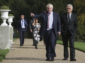 Britain's Foreign Secretary Boris Johnson, left, walks with Slovenia's State Secretary at the Ministry of Foreign Affairs Andrej Logar within the grounds of Chevening House, the British foreign secretary's official residence, in southern England, Sunday Oct. 15, 2017.   Johnson held talks with visiting delegations from European foreign ministers to discuss shared challenges and European security. (Daniel Leal Olivas/pool via AP)