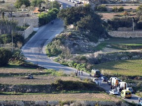 An ambulance and police vehicles are parked along the road where a car bomb exploded killing investigative journalist Daphne Caruana Galizia, in the town of Mosta, Malta, Monday, Oct. 16, 2017. Malta's prime minister says a car bomb has killed an investigative journalist on the island nation. Prime Minister Joseph Muscat said the bomb that killed reporter Daphne Caruana Galizia exploded Monday afternoon as she left her home in a town outside Malta's capital, Valetta. (AP Photo/Rene Rossignaud)