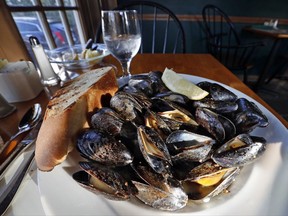 In this Wednesday, Oct. 4, 2017 photo a plate of fire-roasted mussels sits at a restaurant in Freeport, Maine. The state's mussels are beloved by seafood fans near and far, but the annual harvest has dipped in recent years. Harvesters collected less than 1.8 million pounds of mussel meat in 2016. (AP Photo/Robert F. Bukaty)