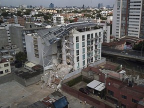 This Sept. 24, 2017 photo shows an apartment building that was partially destroyed during the 7.1 magnitude earthquake, on Emiliano Zapata Avenue in Mexico City. The eco-friendly apartment building with its wood-paneled balconies and a solar-paneled roof collapsed when a corner column failed, and the flat-slab structure pancaked, said Eduardo Miranda, a professor of civil and environmental engineering at Stanford and global expert on earthquake-resistant design. (AP Photo/Miguel Tovar)