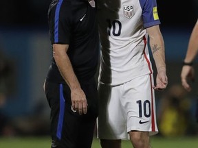 United States' Christian Pulisic, right, is comforted by a member of the team staff after the U.S. lost to Trinidad and Tobago in their World Cup qualifying match, at Ato Boldon Stadium in Couva, Trinidad and Tobago, Tuesday, Oct. 10, 2017. (AP Photo/Rebecca Blackwell)