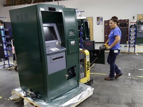 In this Wednesday, Aug. 30, 2017, photo, employee Maria Edney moves an automated teller machine during the manufacturing process at Diebold Nixdorf in Greensboro, N.C. On Monday, Oct. 2, 2017, the  Institute for Supply Management releases its service sector index for September. (AP Photo/Gerry Broome)