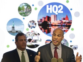 New Jersey Sen. Cory Booker, right, speaks while New Jersey Gov. Chris Christie stands behind him during an announcement in Newark, N.J., Monday, Oct. 16, 2017. The New Jersey lawmakers announced they are submitting a bid to Amazon that Newark would be the best location for their planned second headquarters. (AP Photo/Seth Wenig)