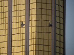 Drapes billow out of broken windows at the Mandalay Bay resort and casino Monday, Oct. 2, 2017, on the Las Vegas Strip following a mass shooting at a music festival in Las Vegas. Authorities say Stephen Craig Paddock broke the windows and began firing with a cache of weapons, killing dozens and injuring hundreds. (AP Photo/John Locher)
