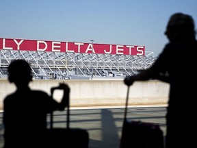 FILE - In this Thursday, Oct. 13, 2016, file photo, a Delta Air Lines sign overlooks the unloading area at Hartsfield-Jackson Atlanta International Airport, in Atlanta. Delta Air Lines, Inc. reports earnings, Wednesday, Oct. 11, 2017. (AP Photo/David Goldman, File)