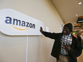 In this Monday, Oct. 16, 2017, photo, Zavian Tate, a student at the University of Alabama at Birmingham, pushes a large Amazon Dash button, in Birmingham, Ala. The large Dash buttons are part of the city's campaign to lure Amazon's second headquarters to Birmingham. (AP Photo/Brynn Anderson)