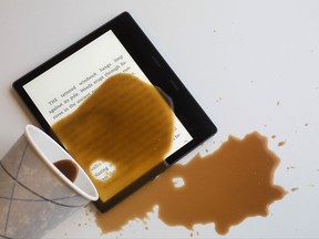 Coffee is spilled onto a new Kindle Oasis E-reader, Tuesday, Oct. 31, 2017, in New York. Amazon's top-of-the-line e-reader is now waterproof. (AP Photo/Mark Lennihan)