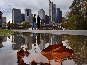 A leaf lies in a puddle where the skyline of the banking district is reflected in Frankfurt, Germany, on a rainy Sunday, Oct. 22, 2017. (AP Photo/Michael Probst)