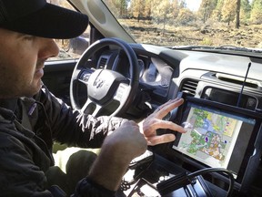 In this Sept. 28, 2017, photo, U.S. Forest Service fire manager James Osborne looks at a map showing previous fires while driving near Sisters, Ore. The thinning of forests in central Oregon has saved homes amid one of the most devastating wildfire seasons in the American West. Osborne showed a section of the Deschutes National Forest outside Sisters that was thinned in May. Widely spaced Ponderosas were blackened to twice the height of a person. But higher up, the bark retained its normal orangey color. (AP Photo/Andrew Selsky)