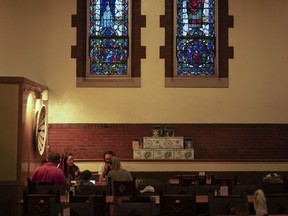 In this Aug. 7, 2017 photo, patrons sit beneath stained glass windows at the Church Brew Works, a former church renovated into a brewery, in Pittsburgh. Breweries opening in renovated churches are winning fans but earning disapproval from clergy and worshippers across the U.S. (AP Photo/Dake Kang)