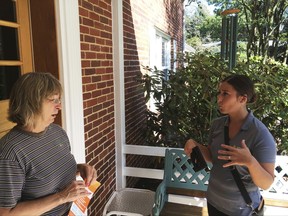 In this Saturday, Sept. 16, 2017, photo, Ashley Klingensmith, right, Pennsylvania field director for Americans for Prosperity, talks with Leora Kirkpatrick about overhauling the tax code, in Wormleysburg, Pa. Even a master salesman like President Donald Trump needs help to convince ordinary people that U.S. corporations desperately need to have their taxes cut. Which is why Klingensmith has been going door-to-door with other canvassers to ask homeowners to support lower taxes for corporations. (AP Photo/Josh Boak)