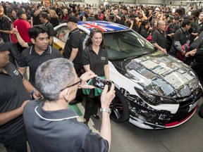 In this photo provided by Toyota Australia, employees gather around the last Toyota car produced in Australia as it leaves the production line in Melbourne, Tuesday, Oct. 3, 2017. Toyota closed its manufacturing plant in Melbourne, ending 54 years of production by the Japanese firm in Australia, the first country outside of Japan where the company made cars. (Toyota Australia via AP)
