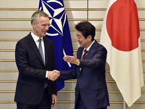 NATO Secretary General Jens Stoltenberg, left, shakes hands with Japan's Prime Minister Shinzo Abe at Abe's official residence in Tokyo Tuesday, Oct. 31, 2017. (Kazuhiro Nogi/Pool Photo via AP)