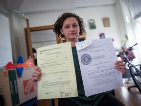 Stand.earth (formerly Forest Ethics) campaign associate Hayley Zacks holds a copy of a notice of civil enforcement and a federal court of appeal ruling delivered to their office by a bailiff notifying them of the seizure of assets relating to a $14,559.19 judgement owing to Enbridge from a Line 9 pipeline court challenge, in Vancouver on Tuesday, October 17, 2017. THE CANADIAN PRESS/Darryl Dyck