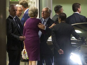 European Commission President Jean-Claude Juncker, center right, embraces British Prime Minister Theresa May, center left, after a meeting at EU headquarters in Brussels on Monday, Oct. 16, 2017. EU officials said that a meeting between British Prime Minister Theresa May and EU officials on Monday evening would span much more than the struggling Brexit talks to include current trade relations with global partners. (AP Photo/Virginia Mayo)