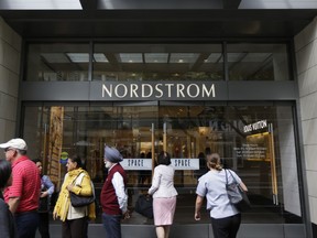 In this Wednesday, Sept. 13, 2017, photo, people stand near an entrance for Nordstrom Inc.'s flagship store in downtown Seattle. In information released Tuesday, Oct. 3, 2017, the National Retail Federation is forecasting holiday sales for the November and December period to rise between 3.6 percent and 4 percent to $678.75 billion to $682 billion. (AP Photo/Ted S. Warren)