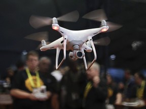 FILE - In this Jan. 5, 2017 file photo, an exhibitor demonstrates a drone flight at CES International, in Las Vegas. White House officials said Trump will sign a memorandum Wednesday permitting states, localities and tribes to craft their own pilot programs to test drones. There is no limit on the number of communities that can participate.  (AP Photo/Jae C. Hong)