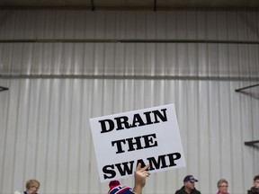 FILE - In this Oct. 27, 2016, file photo, supporters of then-Republican presidential candidate Donald Trump hold signs during a campaign rally in Springfield, Ohio. Despite President Donald Trump's campaign to "drain the swamp" of lobbyists and special interests, Washington's influence industry is alive and well _ and growing. Former members of the Trump transition team, presidential campaign, administration and friends have set up shop as lobbyists and cashed in on connections, according to a new analysis by Public Citizen, a public interest group, and reviewed by The Associated Press.  (AP Photo/ Evan Vucci, file)