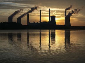 FILE - In this June 3, 2017, file photo, the coal-fired Plant Scherer, one of the nation's top carbon dioxide emitters, stands in the distance in Juliette, Ga. The Trump administration intends to roll back the centerpiece of former President Barack Obama's efforts to slow global warming, seeking to ease restrictions on greenhouse gas emissions from coal-fired power plants. (AP Photo/Branden Camp, File)